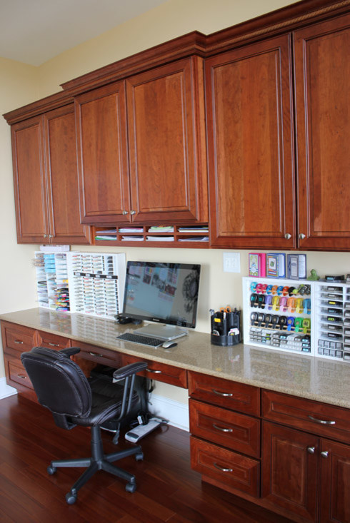 Modern inredning av ett mellanstort hobbyrum, med beige väggar, mellanmörkt trägolv och ett inbyggt skrivbord