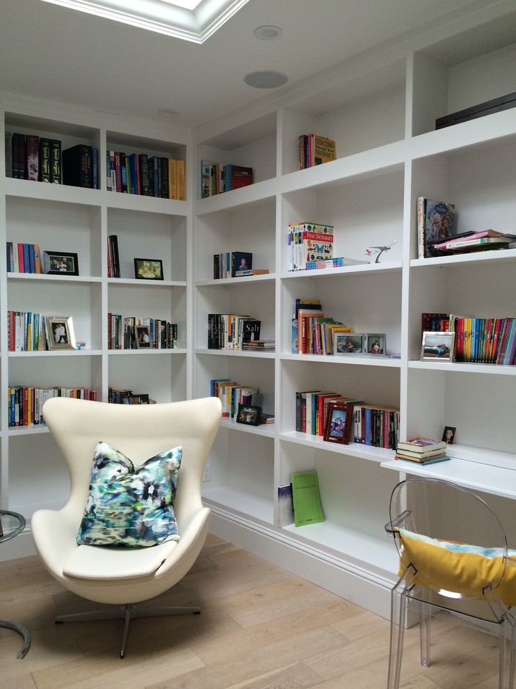 Immagine di uno studio tradizionale di medie dimensioni con libreria, pareti bianche, parquet chiaro e pavimento beige