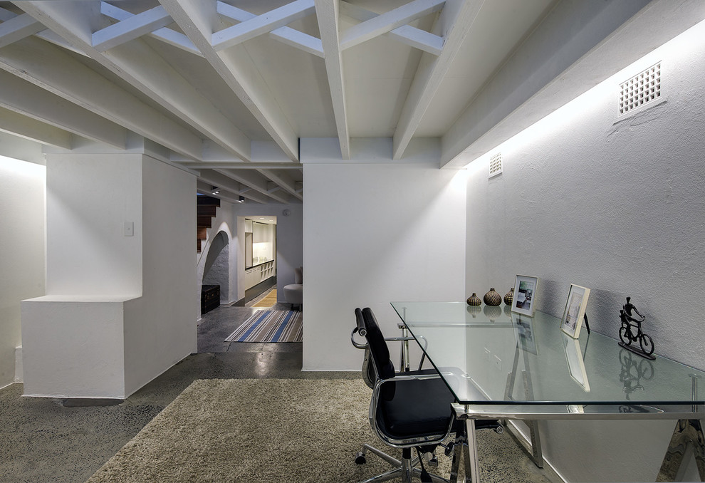 Immagine di un ufficio minimalista di medie dimensioni con pareti bianche, pavimento in cemento e scrivania autoportante