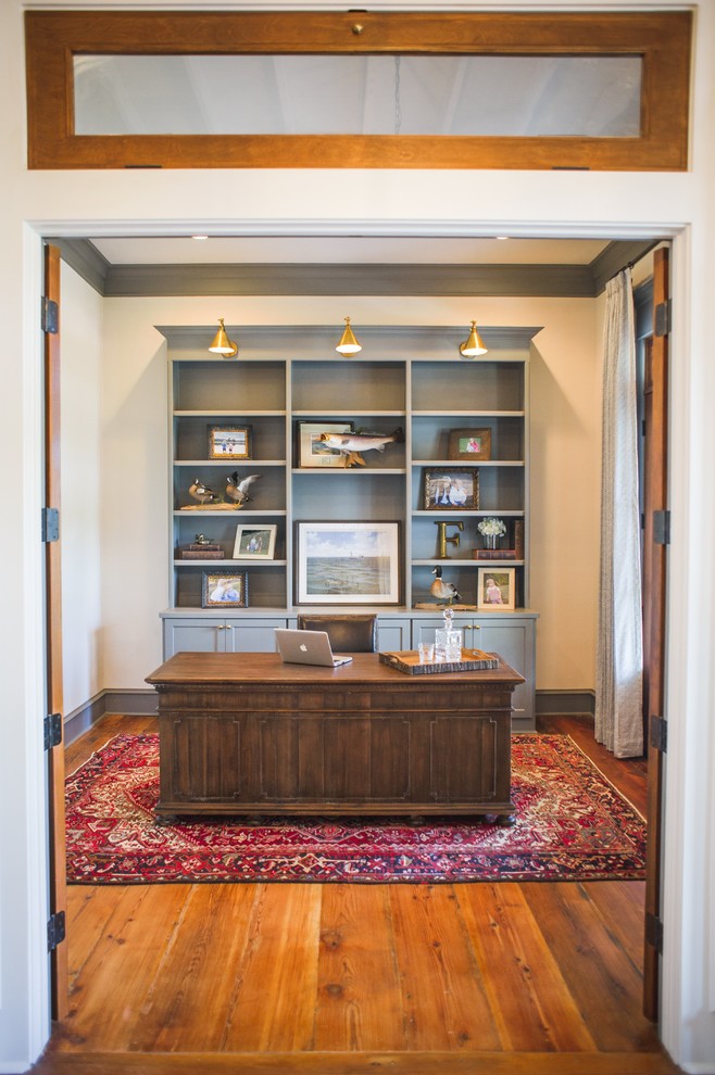 Ejemplo de despacho clásico grande sin chimenea con paredes blancas, suelo de madera en tonos medios, escritorio independiente y suelo marrón