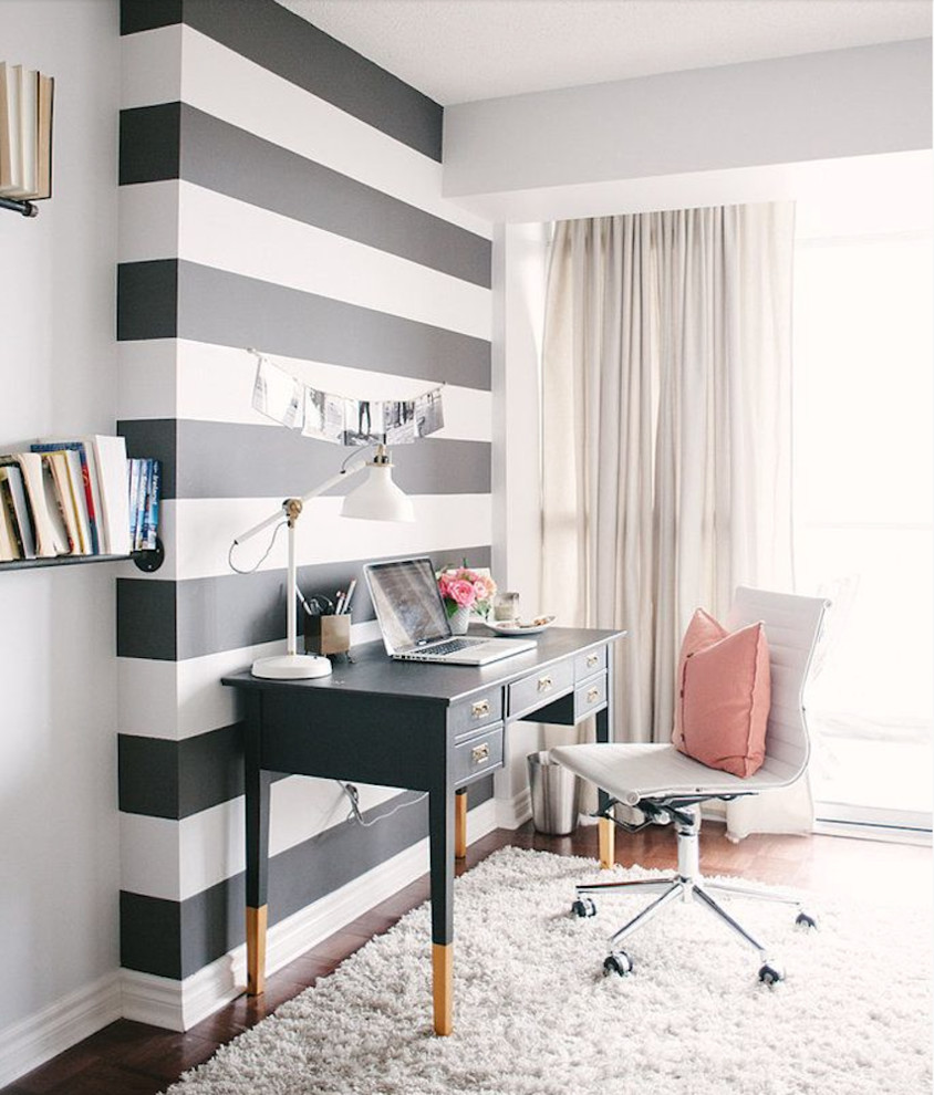 Imagen de despacho minimalista de tamaño medio sin chimenea con paredes negras, suelo de madera oscura y escritorio independiente