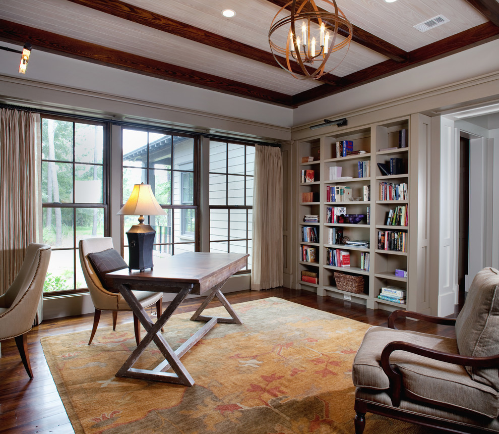 Mittelgroßes Klassisches Arbeitszimmer mit Arbeitsplatz, beiger Wandfarbe, dunklem Holzboden und freistehendem Schreibtisch in Charleston
