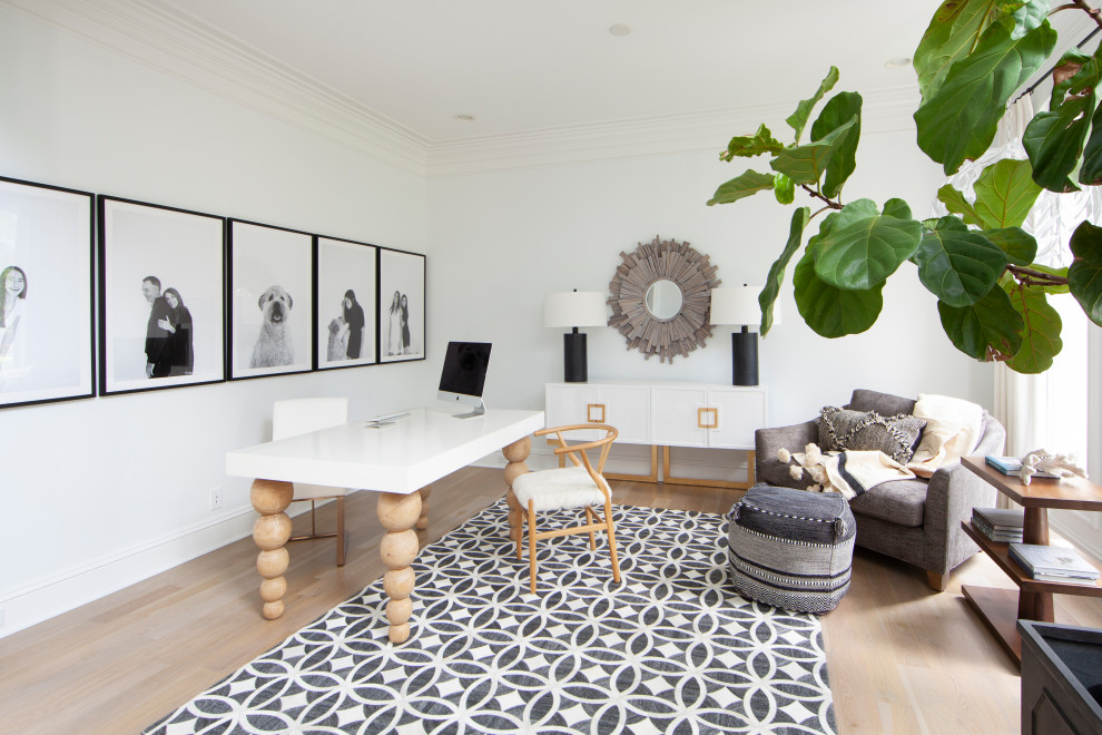 Idéer för funkis arbetsrum, med vita väggar, ljust trägolv, ett fristående skrivbord och beiget golv