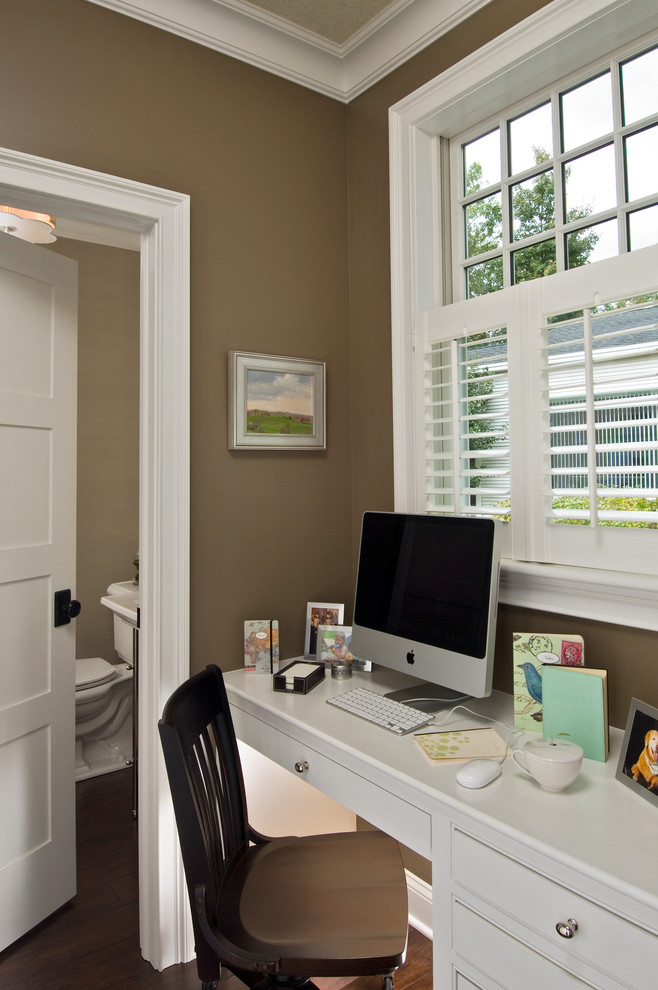 This is an example of a traditional home office in New York with brown walls.