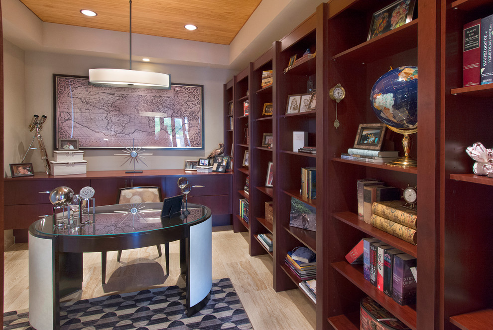Foto på ett funkis hemmabibliotek, med grå väggar, ljust trägolv och ett fristående skrivbord