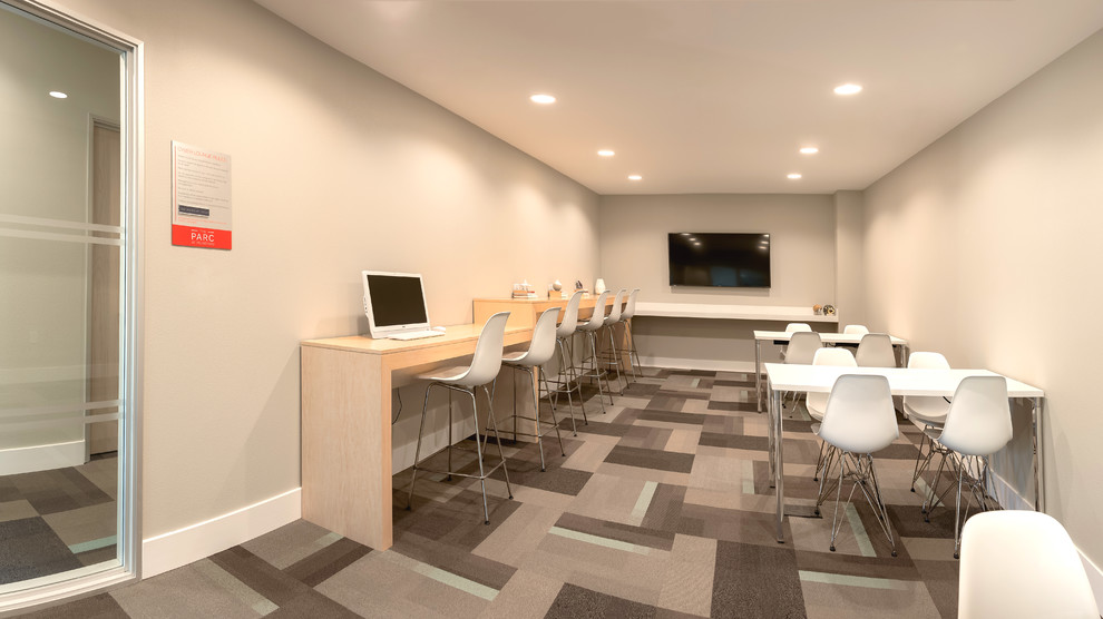 Modelo de despacho actual de tamaño medio con paredes beige, moqueta, escritorio independiente y suelo multicolor