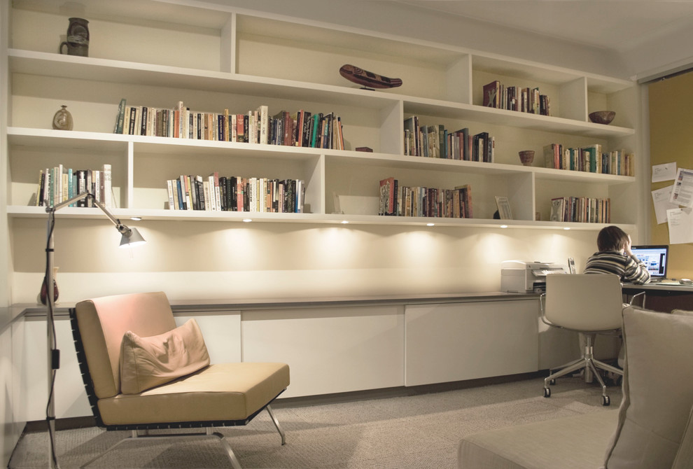 Mittelgroßes Modernes Arbeitszimmer ohne Kamin mit beiger Wandfarbe, Teppichboden, Einbau-Schreibtisch und beigem Boden in New York