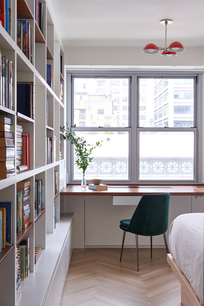 Idéer för att renovera ett funkis arbetsrum, med ett bibliotek, vita väggar, ljust trägolv, ett inbyggt skrivbord och beiget golv
