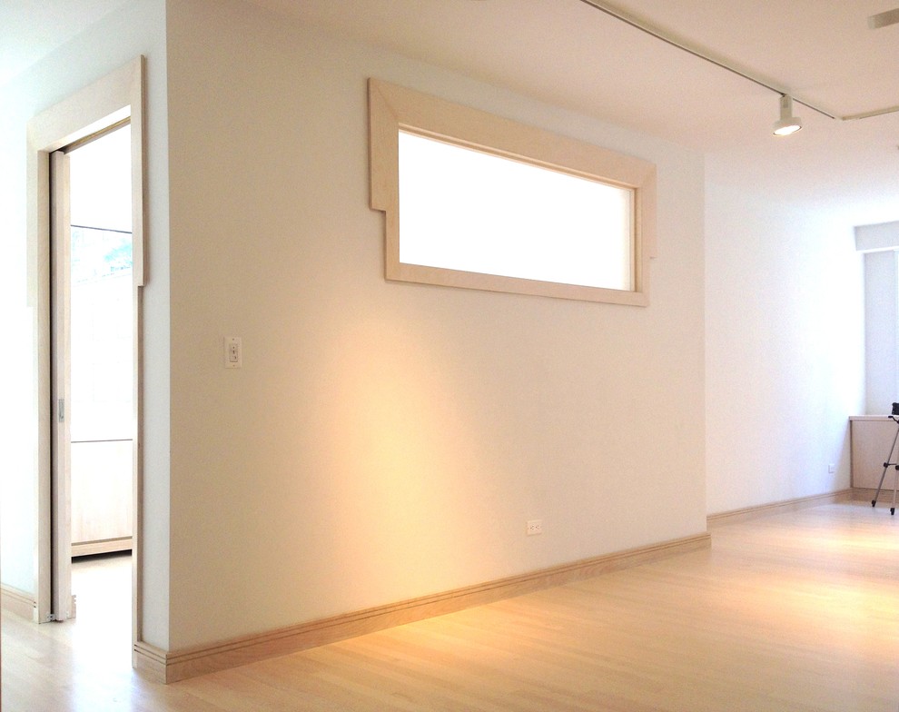 Idée de décoration pour un grand bureau design de type studio avec un mur blanc, parquet clair, un bureau intégré et un sol beige.