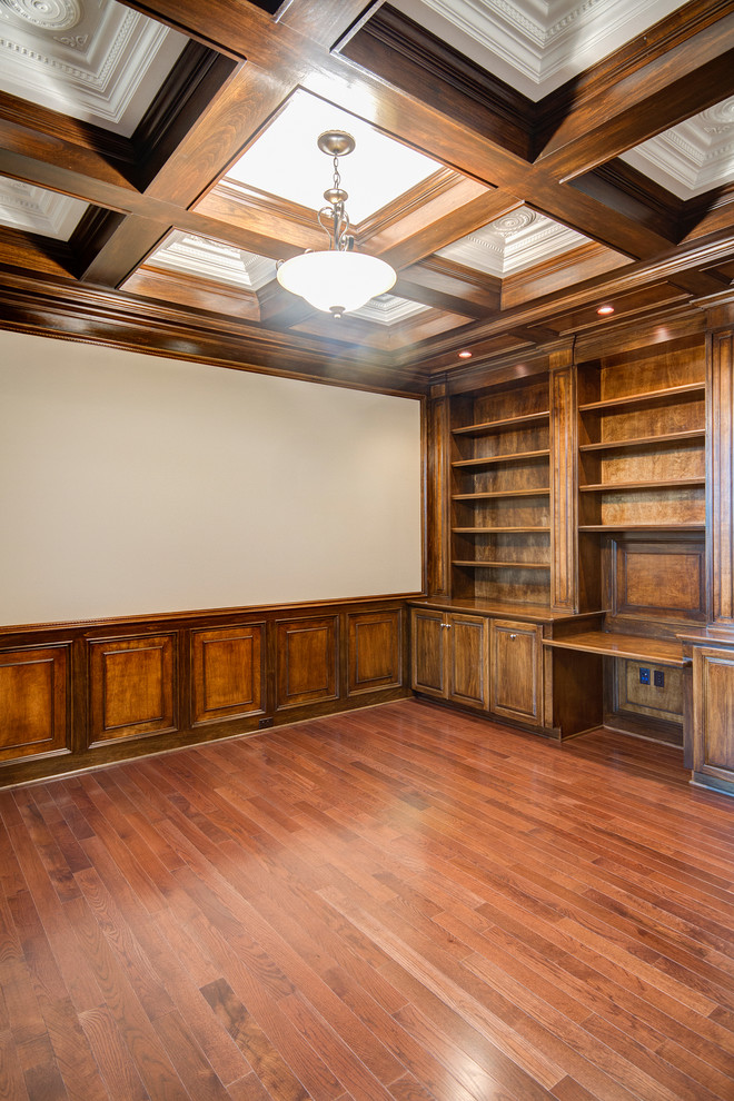 Großes Klassisches Arbeitszimmer ohne Kamin mit Arbeitsplatz, beiger Wandfarbe, braunem Holzboden und Einbau-Schreibtisch in Sonstige