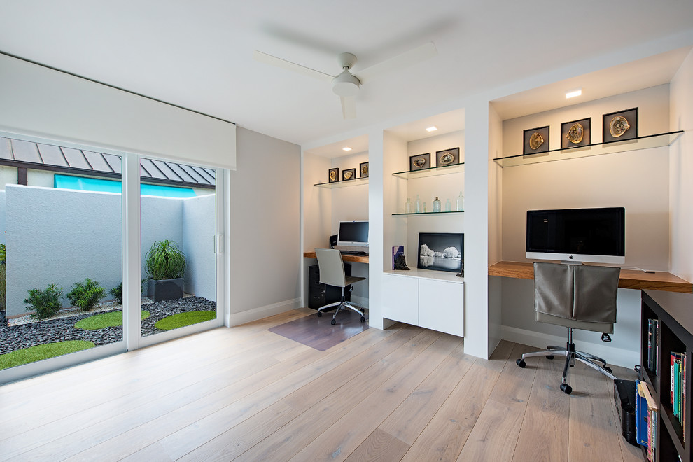 Mid-sized trendy built-in desk light wood floor and beige floor study room photo in Miami with gray walls and no fireplace