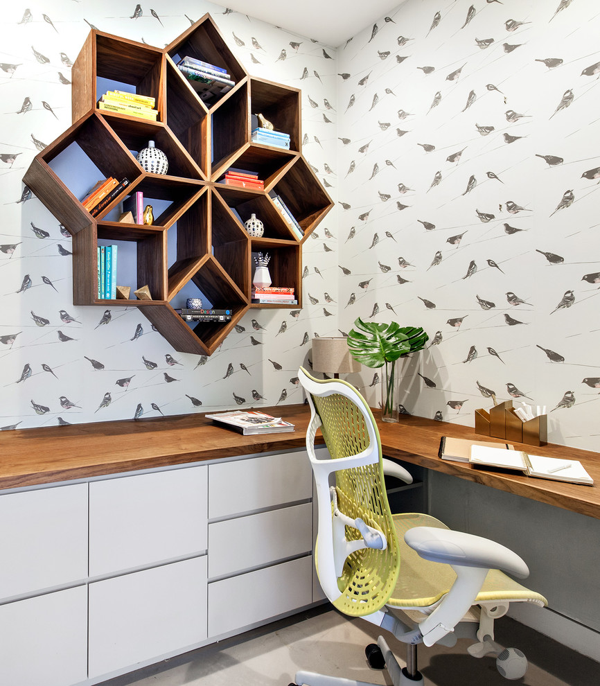 Modelo de despacho actual de tamaño medio sin chimenea con paredes multicolor, suelo de cemento, escritorio empotrado y suelo gris