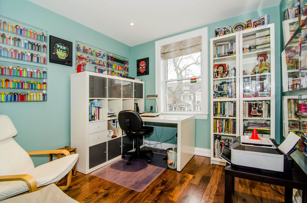 Idéer för funkis arbetsrum, med blå väggar, mellanmörkt trägolv och ett fristående skrivbord