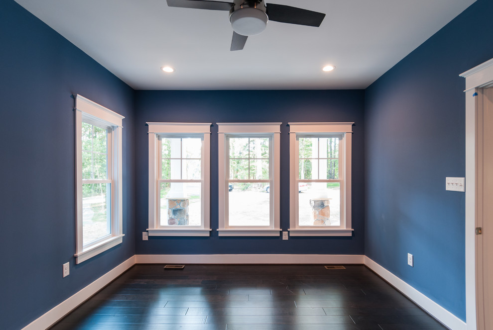 Immagine di un piccolo studio minimal con pareti blu, parquet scuro e pavimento marrone