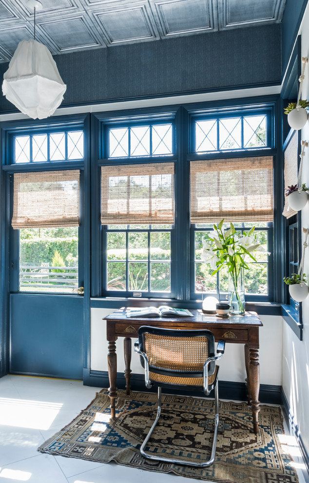 Immagine di un ufficio boho chic con pareti blu, scrivania autoportante e pavimento bianco
