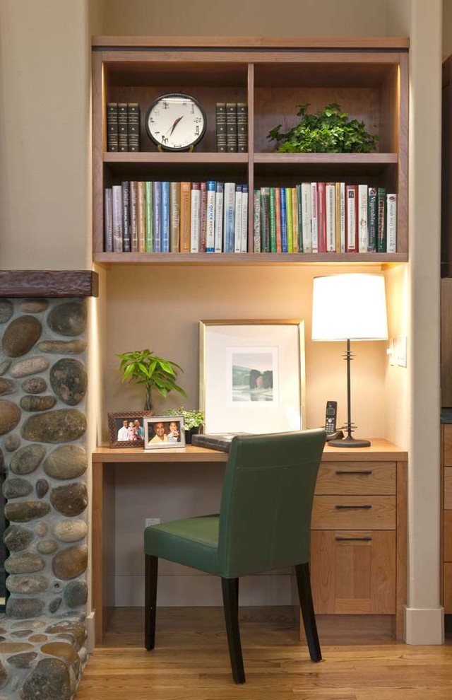 Inspiration pour un petit bureau chalet avec un mur beige, un sol en bois brun, une cheminée standard, un manteau de cheminée en pierre et un bureau indépendant.