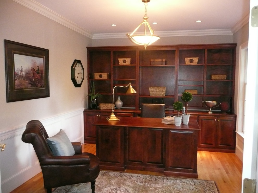 Medium sized traditional study in Boston with grey walls, light hardwood flooring, no fireplace and a freestanding desk.