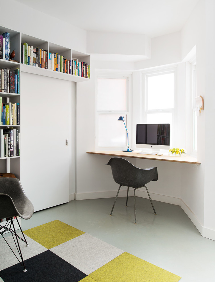 На фото: кабинет в современном стиле с белыми стенами и встроенным рабочим столом с