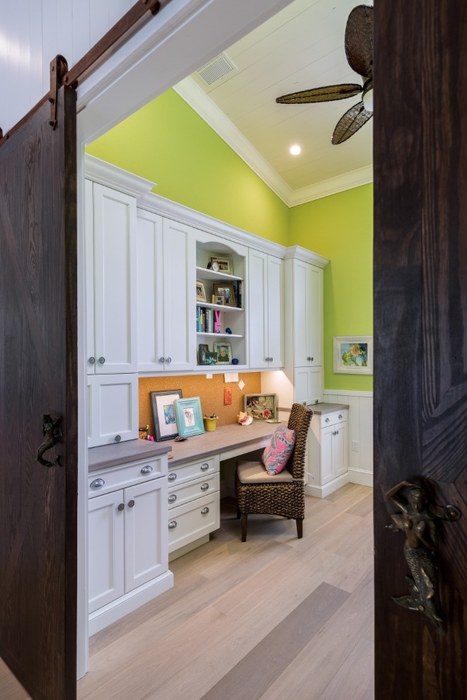 Example of a mid-sized beach style built-in desk light wood floor home office design in Tampa with green walls and no fireplace