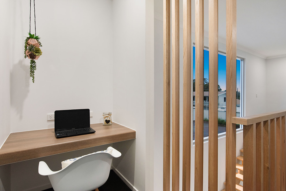 Immagine di un ufficio design con pareti bianche, moquette, scrivania incassata e pavimento nero