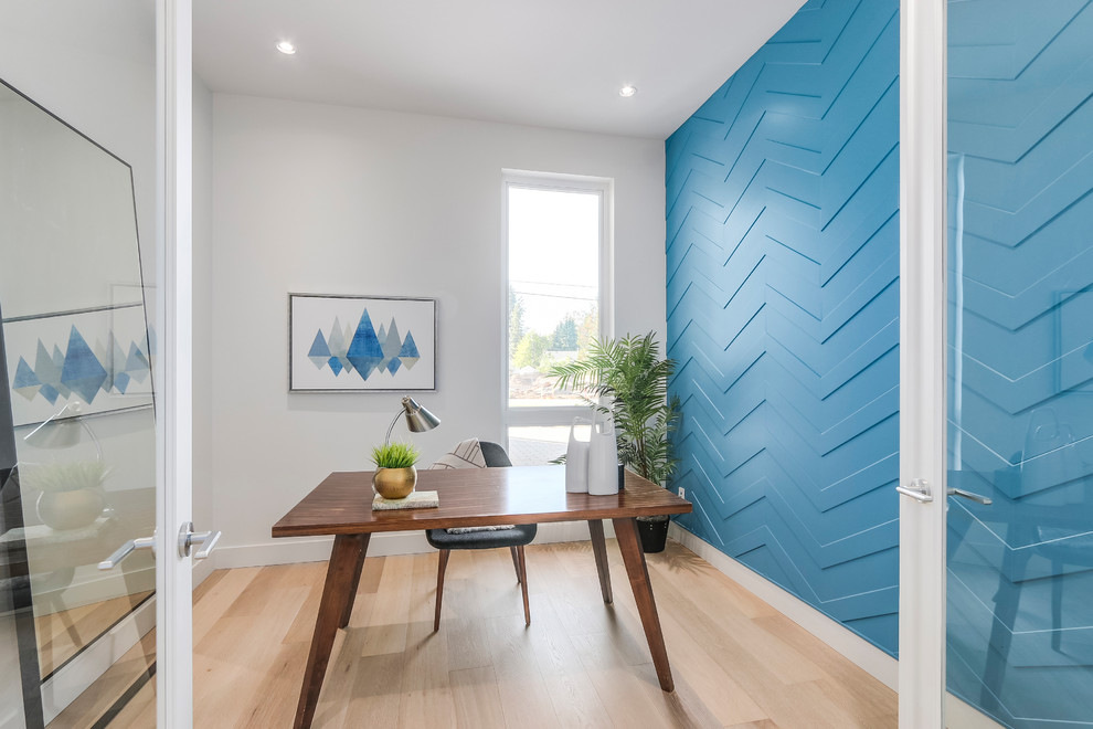 Cette image montre un bureau design de taille moyenne et de type studio avec un mur bleu, parquet clair, aucune cheminée, un bureau indépendant et un sol beige.