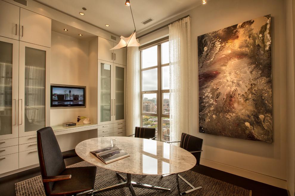 Diseño de despacho contemporáneo con paredes blancas, escritorio empotrado y suelo marrón