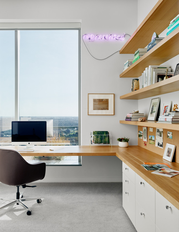 Modelo de despacho contemporáneo sin chimenea con paredes blancas, moqueta, escritorio empotrado y suelo gris