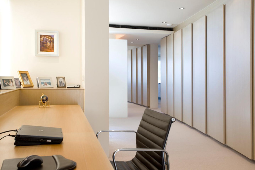 Ejemplo de despacho actual de tamaño medio con paredes blancas, moqueta y escritorio empotrado