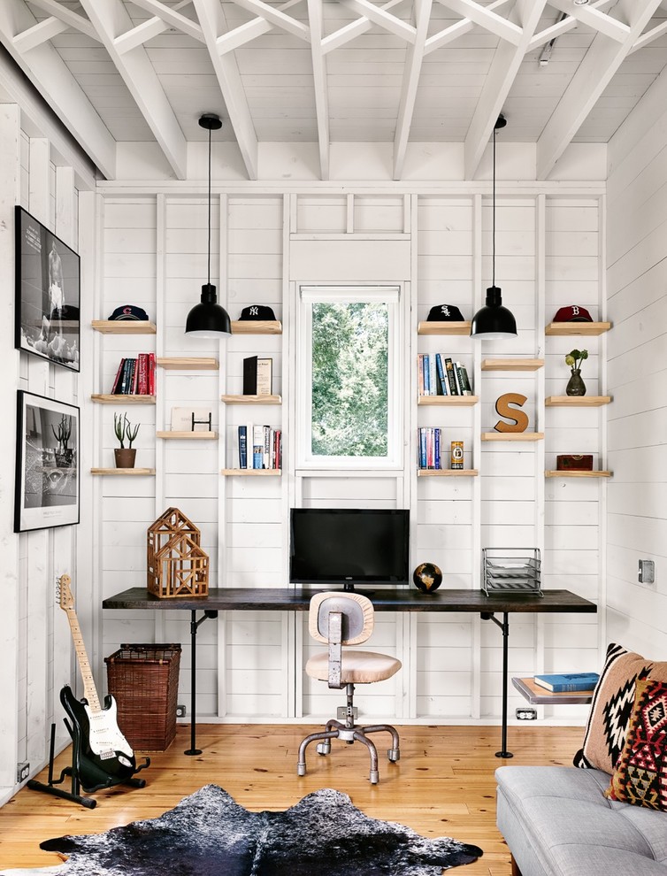 Exempel på ett litet lantligt hemmabibliotek, med vita väggar, ett inbyggt skrivbord och ljust trägolv