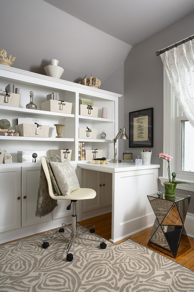 Example of a classic built-in desk medium tone wood floor home office design in Minneapolis with gray walls and no fireplace