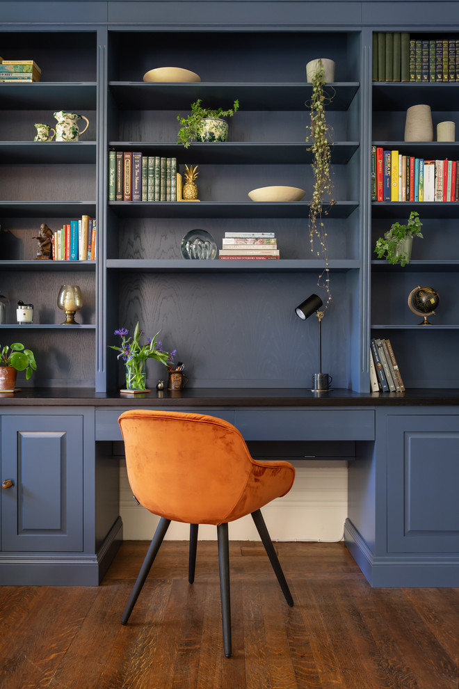На фото: домашняя библиотека в классическом стиле с синими стенами, паркетным полом среднего тона, встроенным рабочим столом и коричневым полом