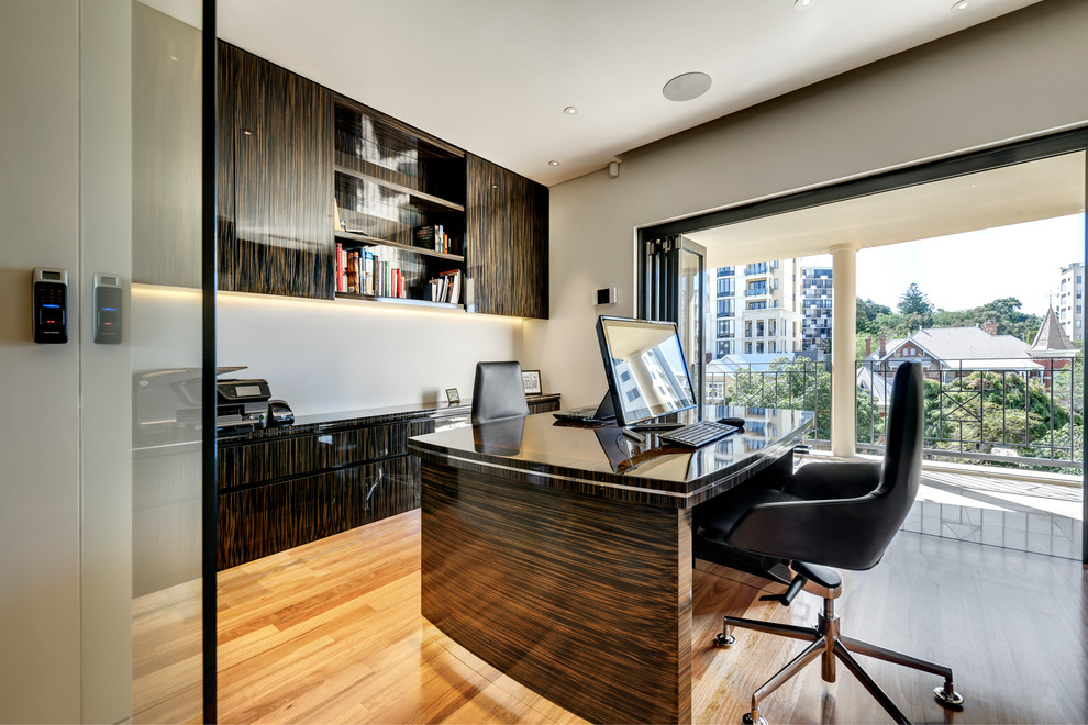 Exemple d'un bureau tendance avec un mur beige, parquet clair et un bureau indépendant.