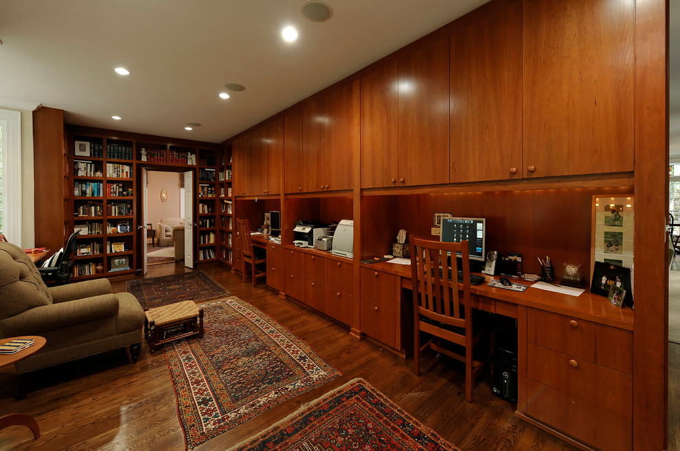 Foto på ett vintage hemmabibliotek, med beige väggar och mellanmörkt trägolv