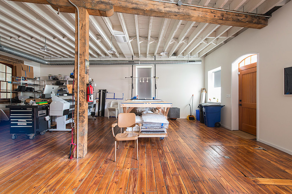 Geräumiges Industrial Arbeitszimmer mit weißer Wandfarbe, braunem Holzboden und freistehendem Schreibtisch in Philadelphia