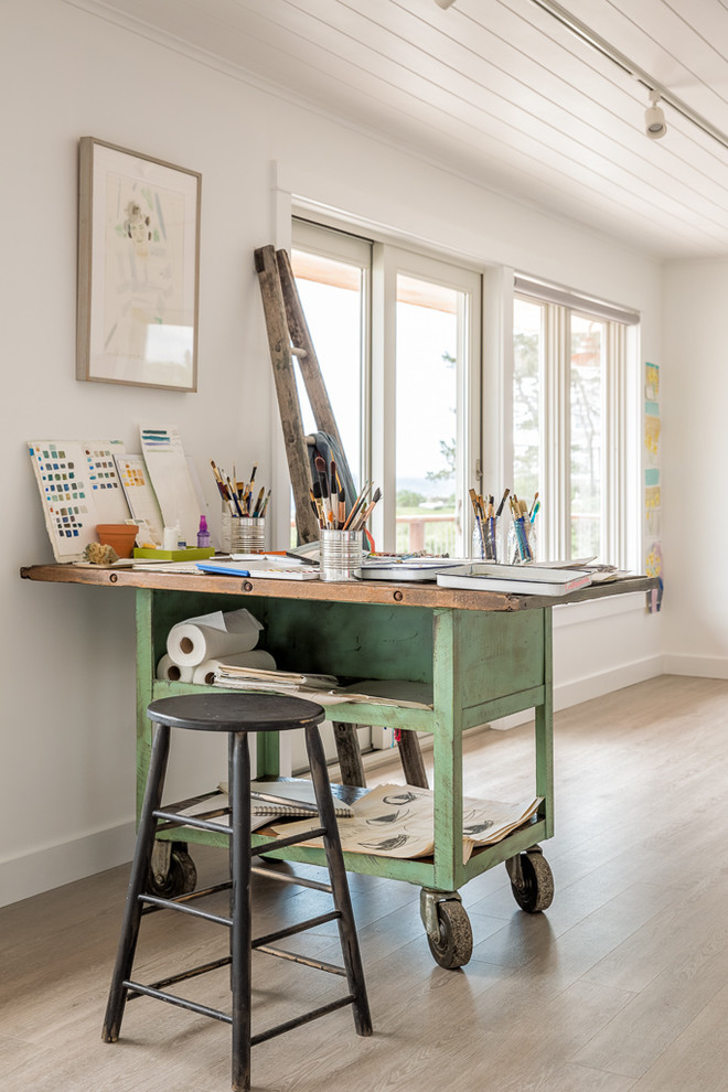 Idee per un atelier stile marinaro con pareti bianche, parquet chiaro, scrivania autoportante e pavimento beige