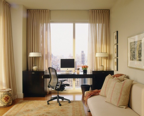 Photo of a study in New York with beige walls, bamboo flooring and a built-in desk.