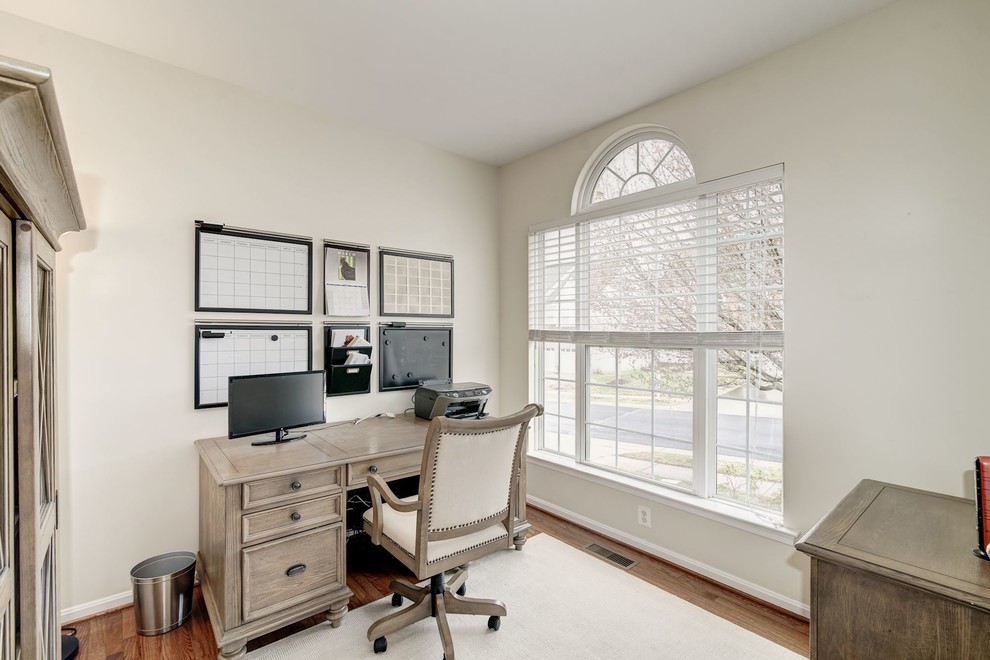Idee per un grande ufficio classico con pareti grigie, pavimento in legno massello medio e scrivania autoportante