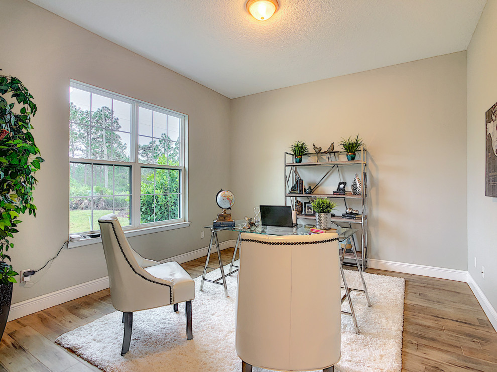 Diseño de despacho minimalista de tamaño medio con paredes grises, suelo de baldosas de porcelana, escritorio independiente y suelo marrón
