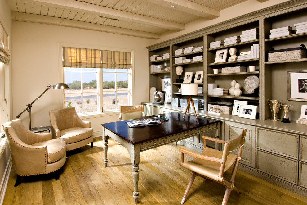 Ejemplo de despacho mediterráneo con paredes blancas, suelo de madera en tonos medios y escritorio empotrado