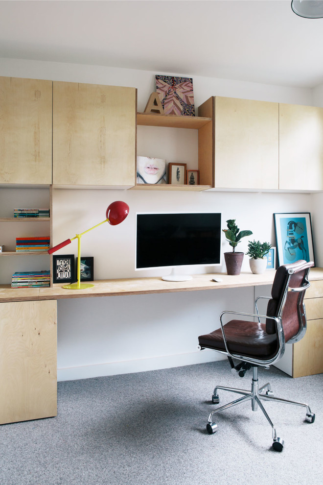 Mid-sized danish built-in desk carpeted and gray floor home office photo in London with white walls