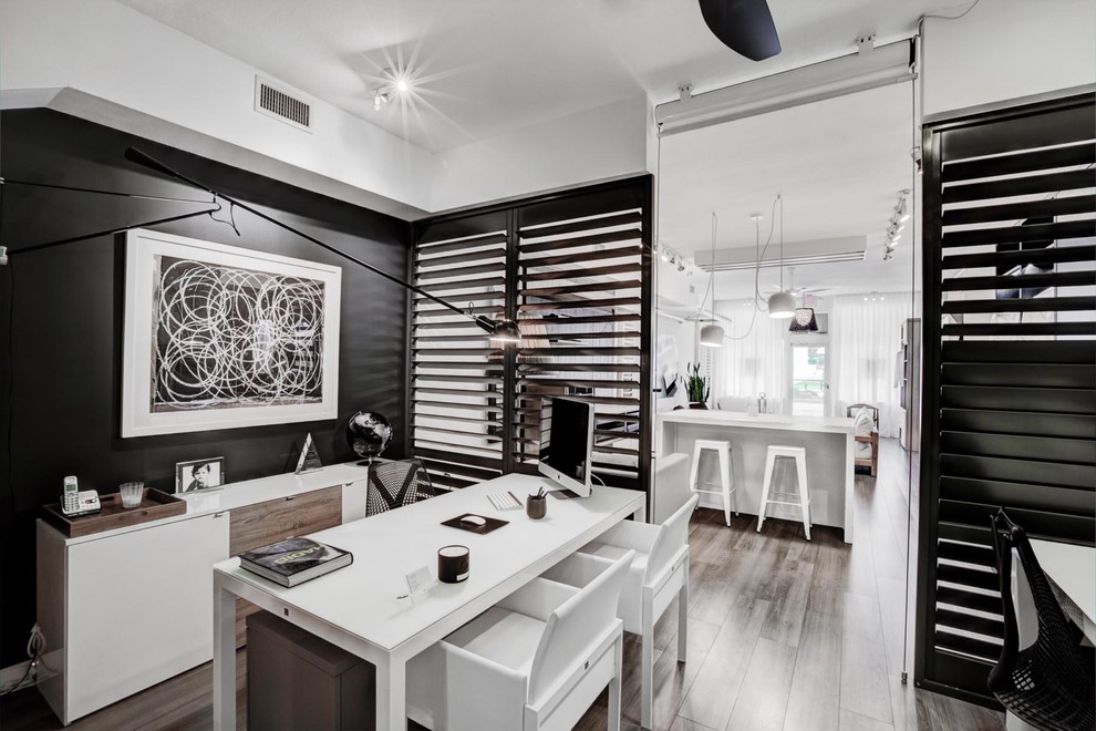 Esempio di un ufficio design con pareti nere, pavimento in legno massello medio e scrivania autoportante