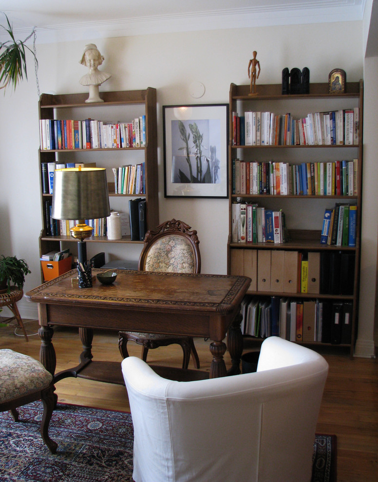 Kleines Klassisches Arbeitszimmer mit Studio, beiger Wandfarbe, hellem Holzboden und freistehendem Schreibtisch in Montreal
