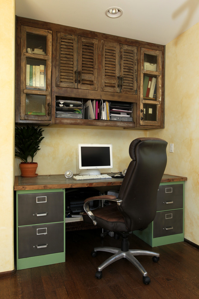 Foto di un piccolo ufficio mediterraneo con parquet scuro, nessun camino, pareti gialle, scrivania incassata e pavimento marrone