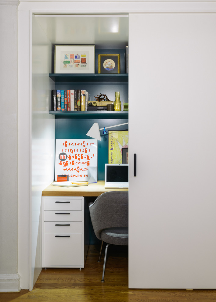 Inspiration pour un petit bureau design avec un mur bleu, un sol en bois brun et un bureau intégré.