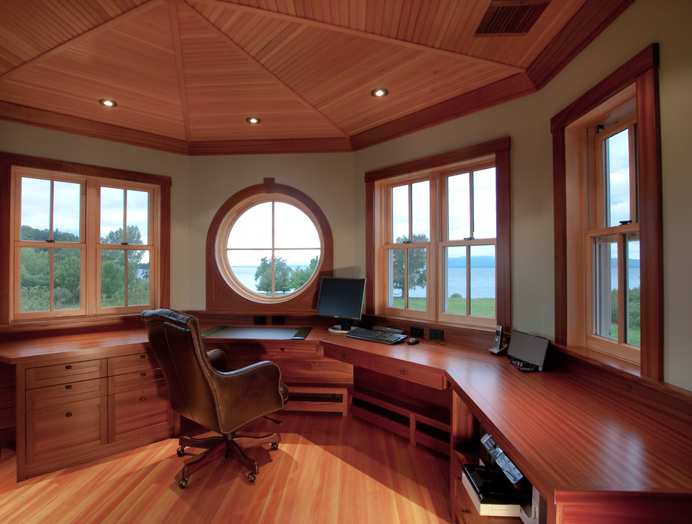 Idéer för ett stort maritimt hemmabibliotek, med beige väggar, ett inbyggt skrivbord och ljust trägolv