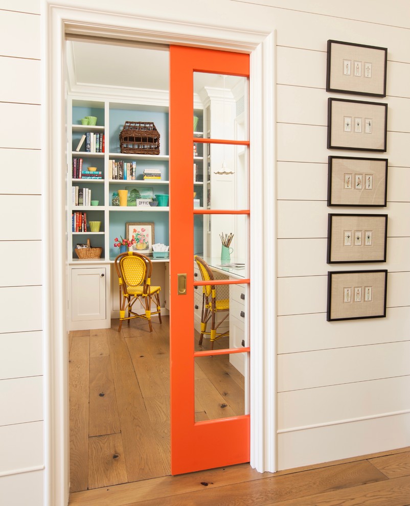 Inspiration for a small country built-in desk light wood floor and brown floor study room remodel in Los Angeles with blue walls