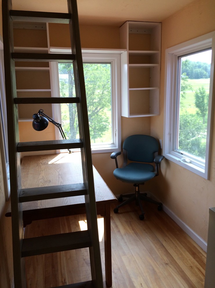 Immagine di uno studio country di medie dimensioni con pareti beige, pavimento in legno massello medio e scrivania autoportante