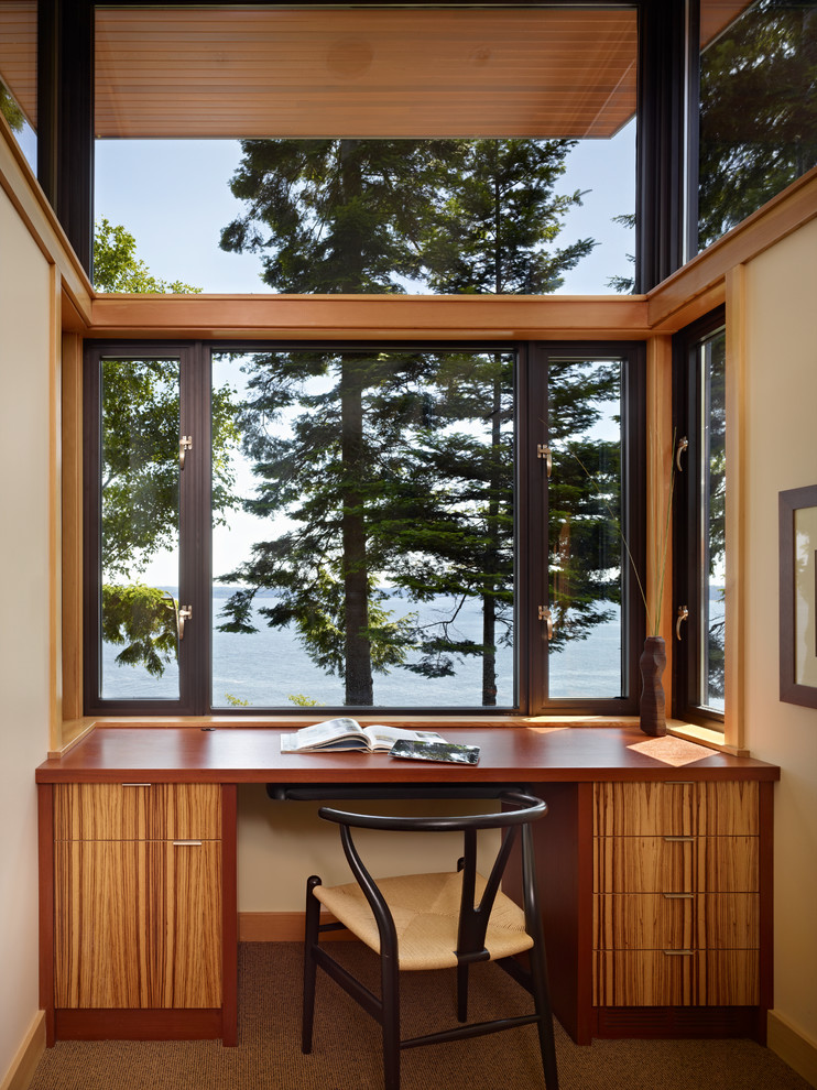 На фото: кабинет в стиле модернизм с встроенным рабочим столом с