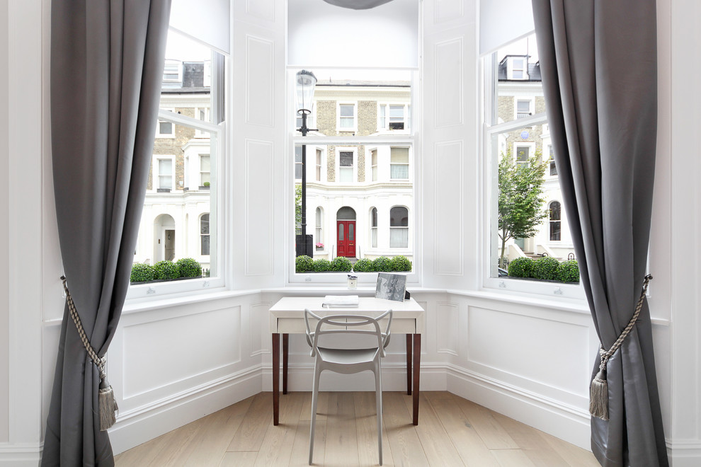 Mittelgroßes Klassisches Arbeitszimmer mit weißer Wandfarbe, hellem Holzboden und freistehendem Schreibtisch in London