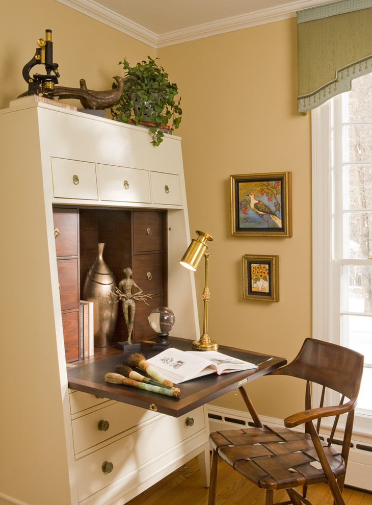 Stilmix Arbeitszimmer mit beiger Wandfarbe, braunem Holzboden und freistehendem Schreibtisch in Bridgeport